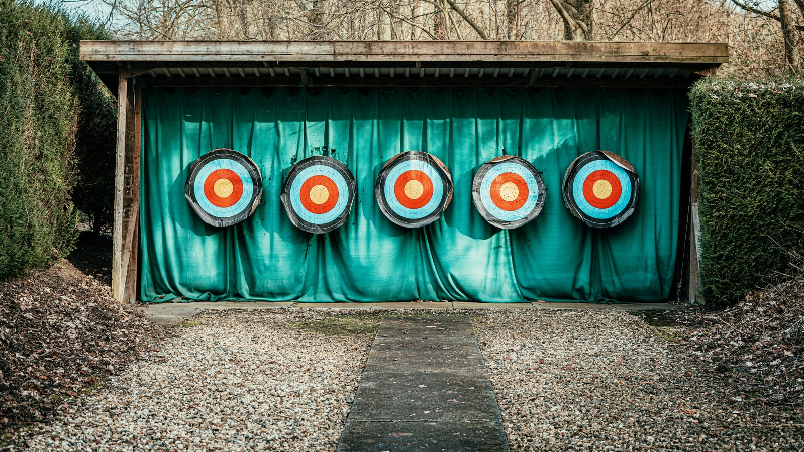 Five round targets lined up side by side on an outdoor firing line