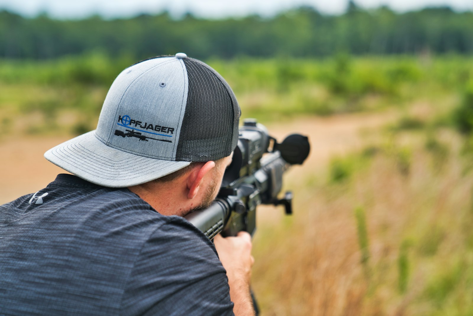 Tireur sportif au stand, casque actif et pistolet sur le pas de tir