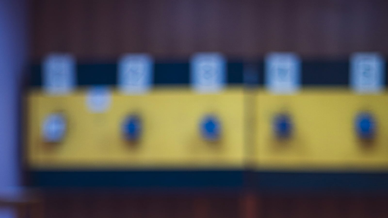 Rifle resting on a wooden shooting bench in an indoor range, with numbered lanes in the background